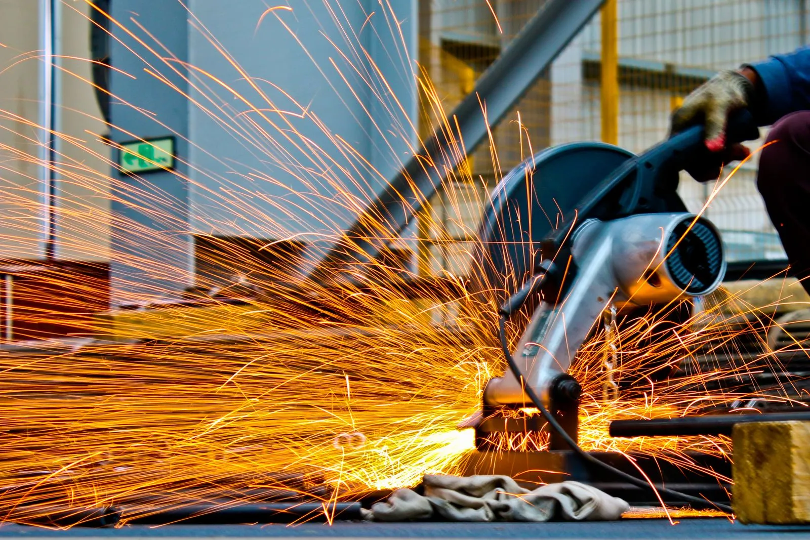Sparks fly as a skilled worker grinds metal on an industrial site