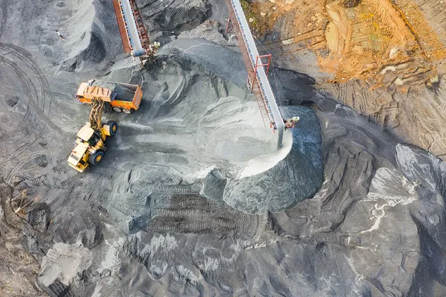 Aerial view of an open-pit mine with a haul truck and excavator