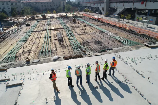 Aerial view of a construction site with safety officers and workers in hi-vis PPE